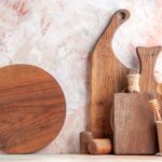 front-view-wooden-brown-cutting-boards-different-sizes-forms-standing-wall-colorful-surface-min